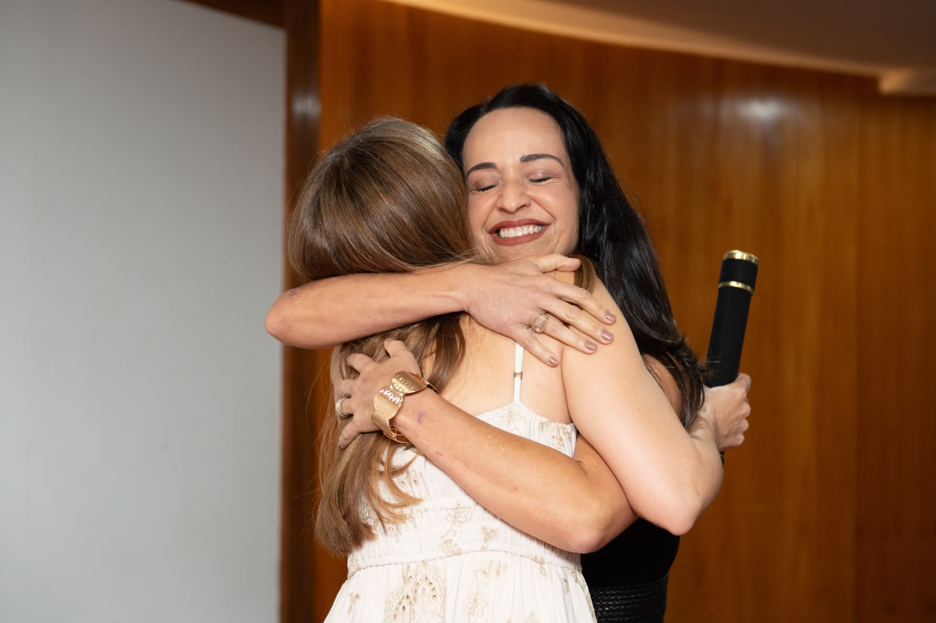 Turma 01 da Pós 2026 — abraço entre alunas com o diploma
