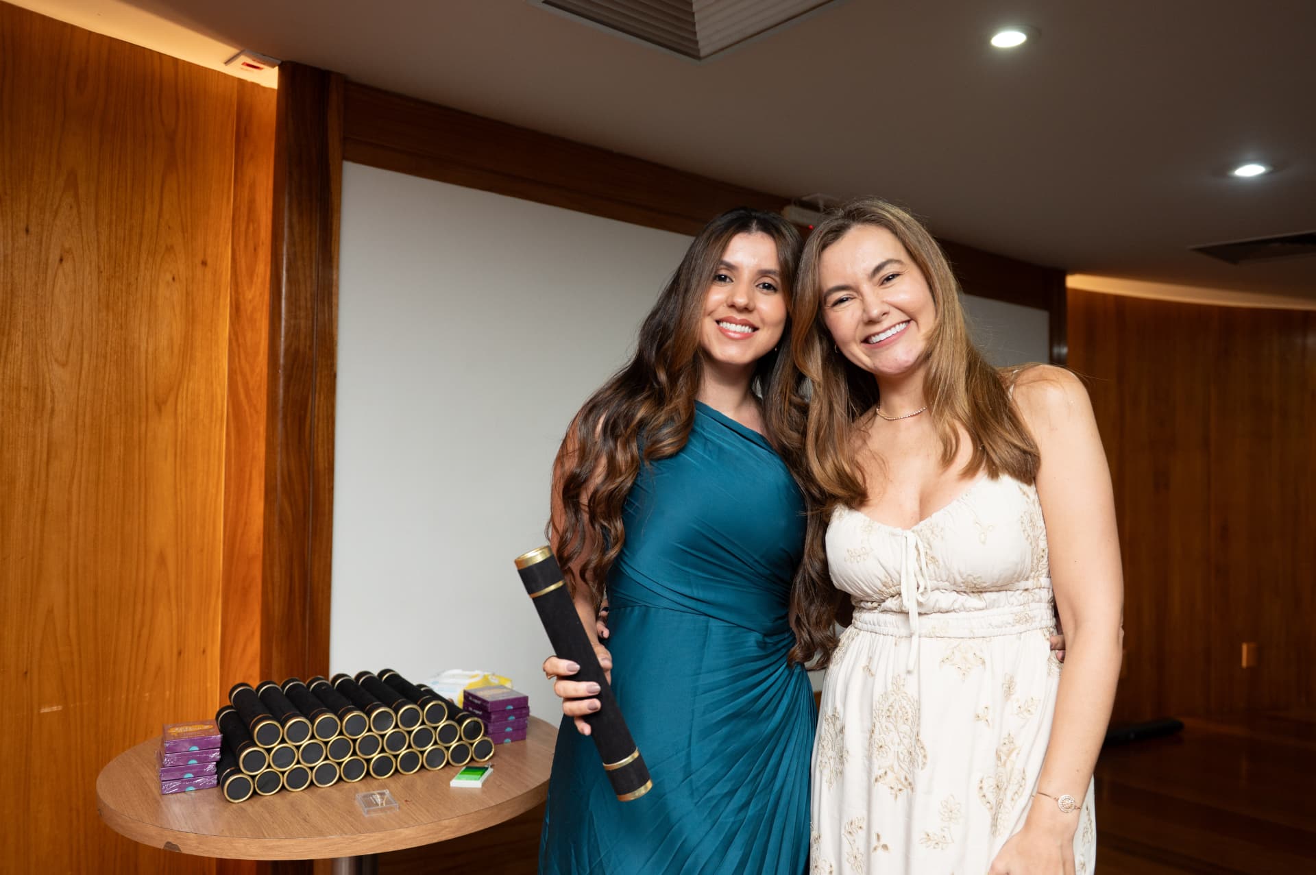 Turma 01 da Pós 2026 — aluna de vestido azul com o diploma