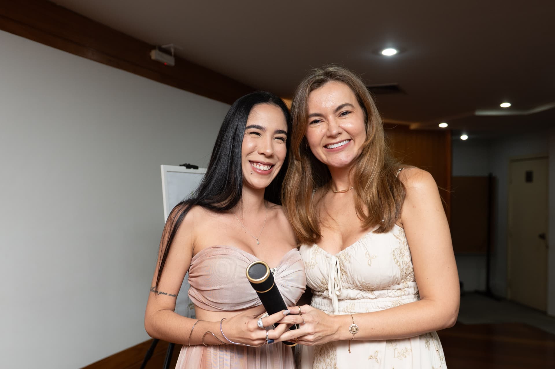 Turma 01 da Pós 2026 — aluna de vestido rosé recebendo o canudo de formatura