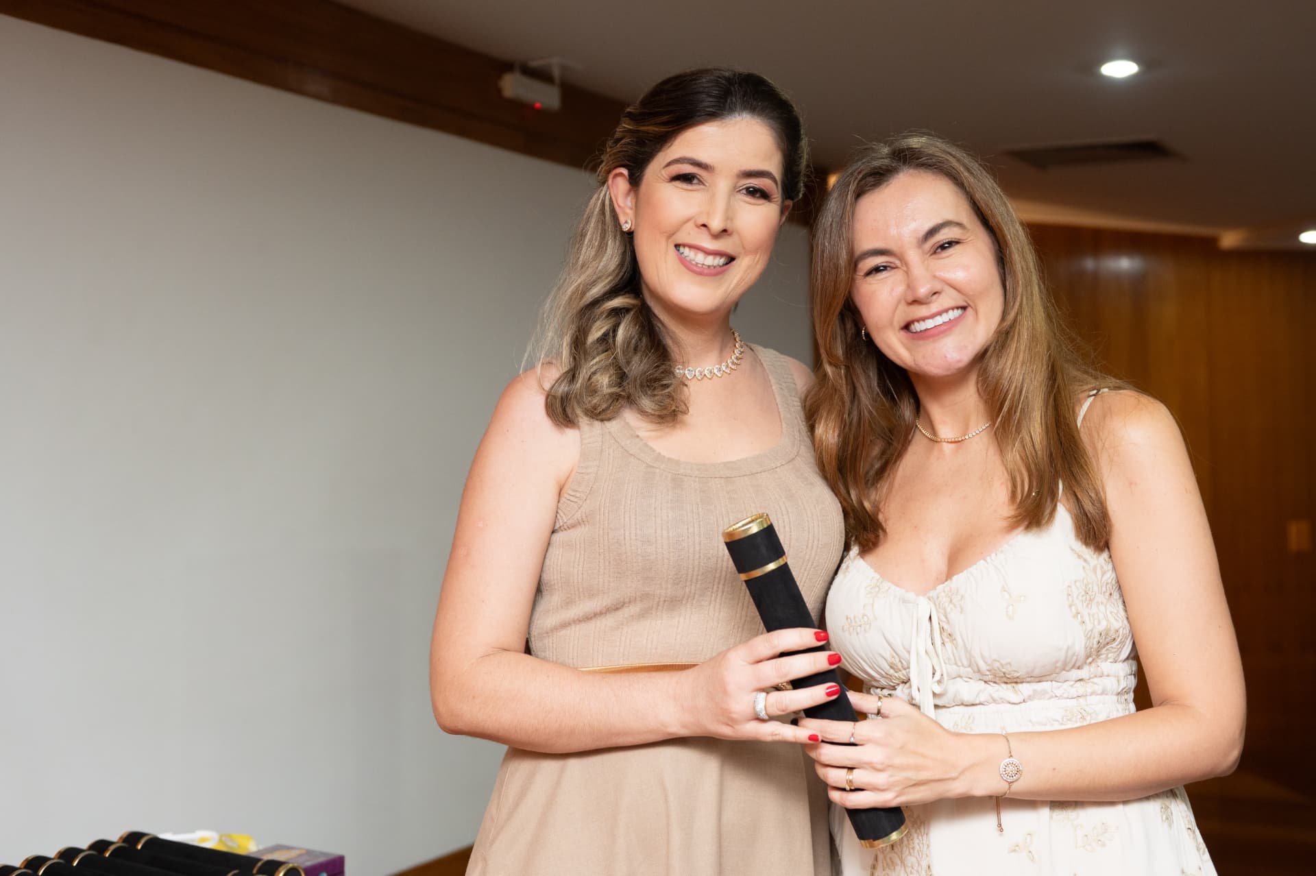 Turma 01 da Pós 2026 — aluna de vestido bege com o diploma