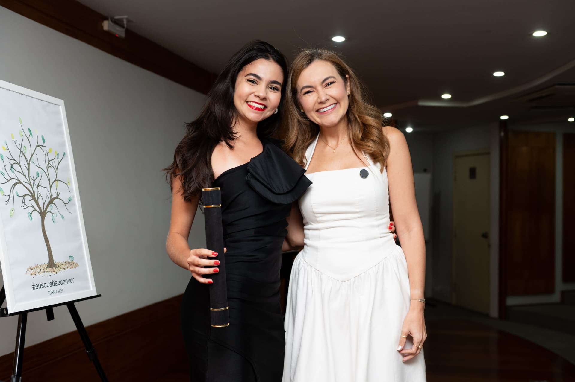 2ª turma — formanda de vestido preto com o canudo de formatura